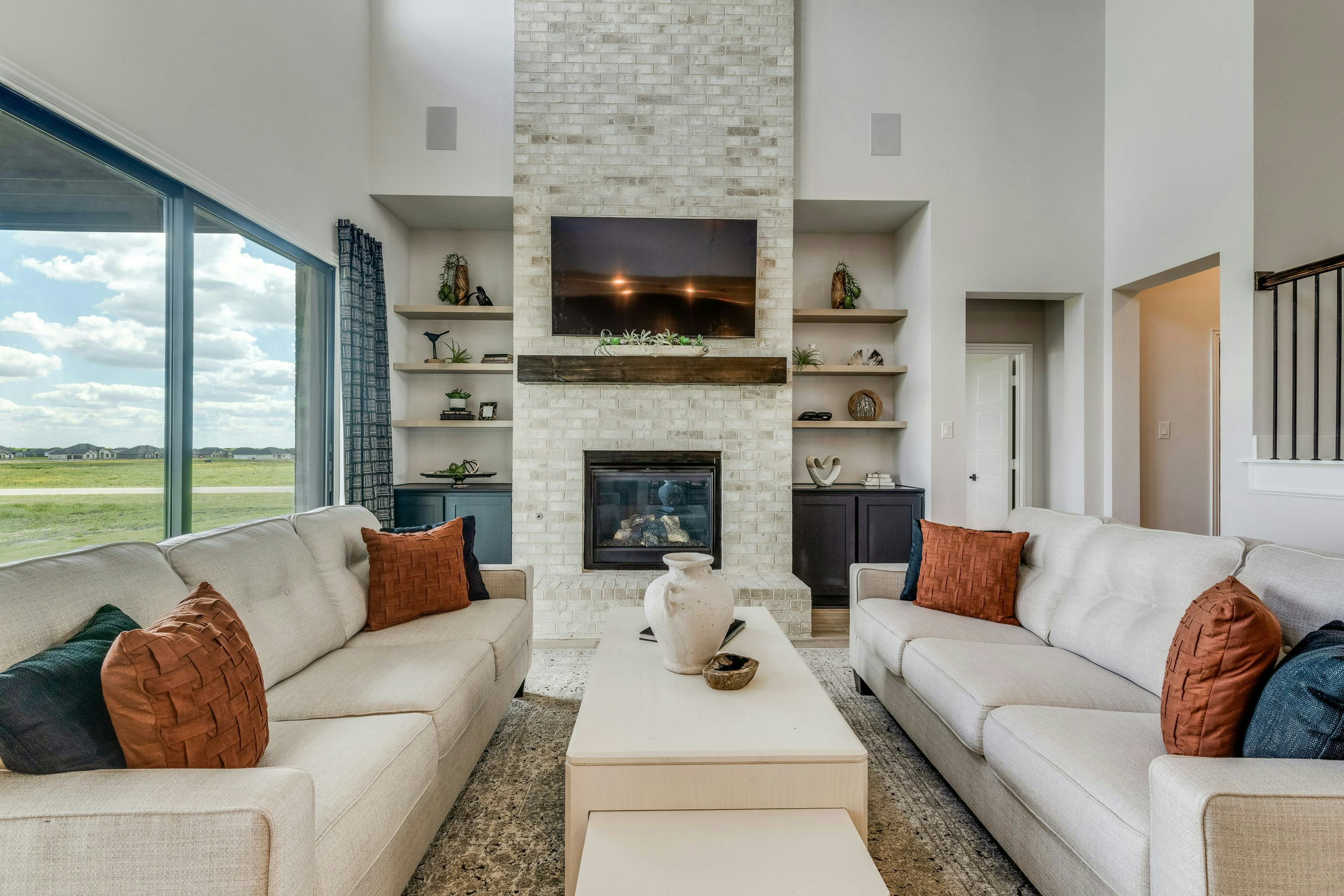 Living room with TV inside Berkshire Estates home in Mesquite, TX by Kindred Homes