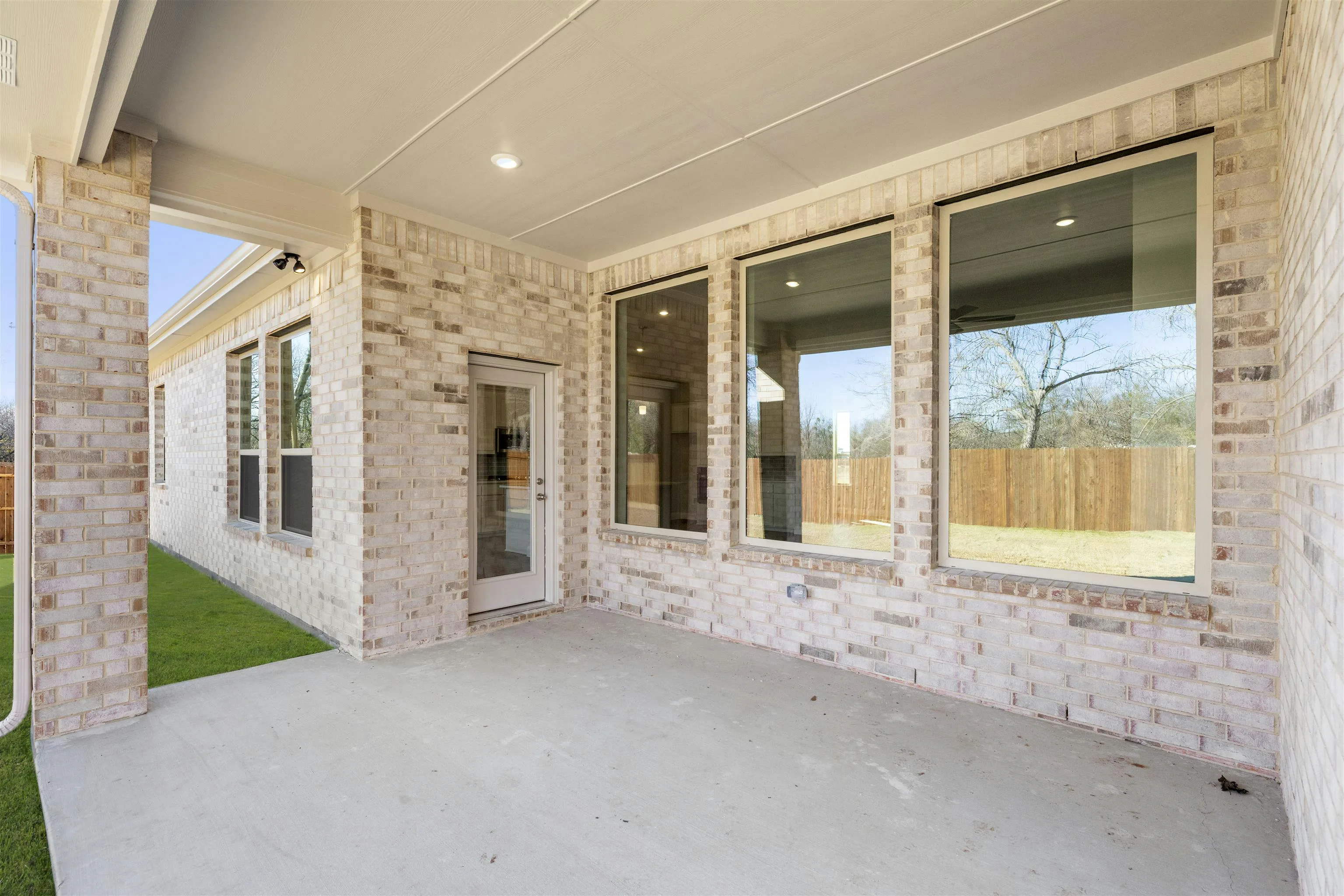 Covered patio in a transitional ranch style home by Kindred Homes
