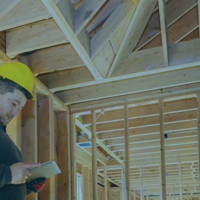 Image of construction worker inspecting the frame of a home