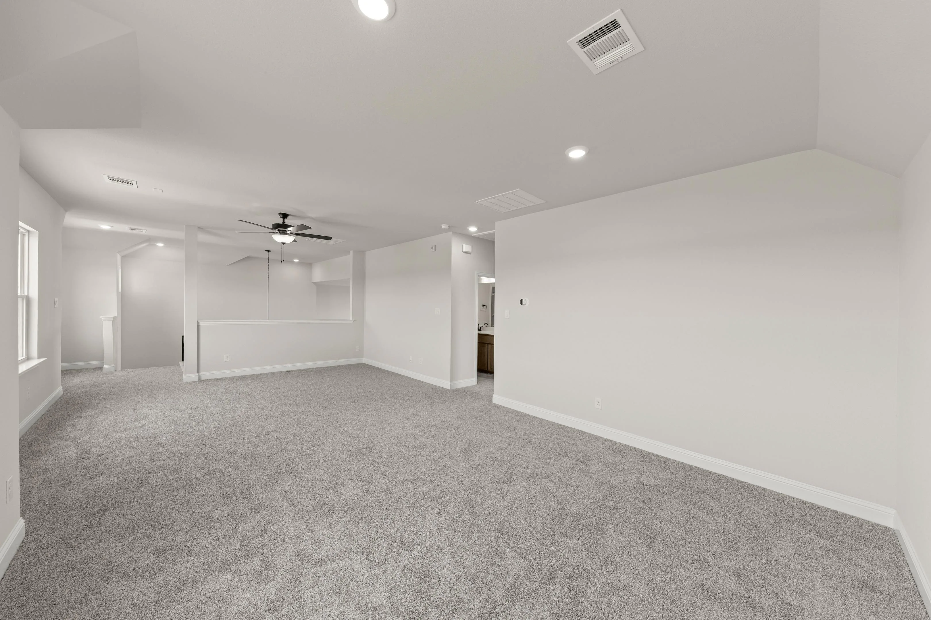 Game room with sitting area and loft in a new traditional style home by Kindred Homes