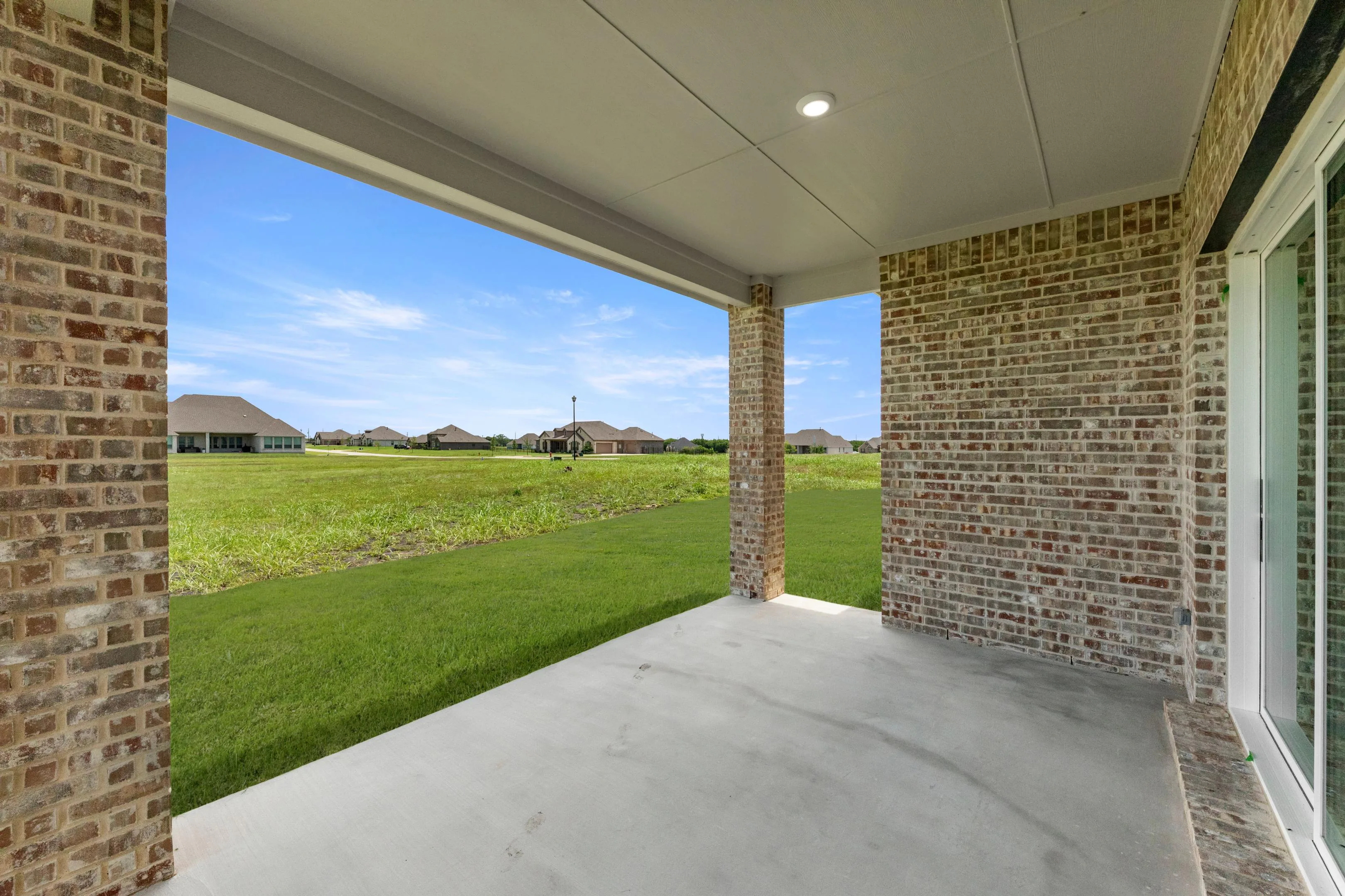 Covered patio in a new traditional style home by Kindred Homes