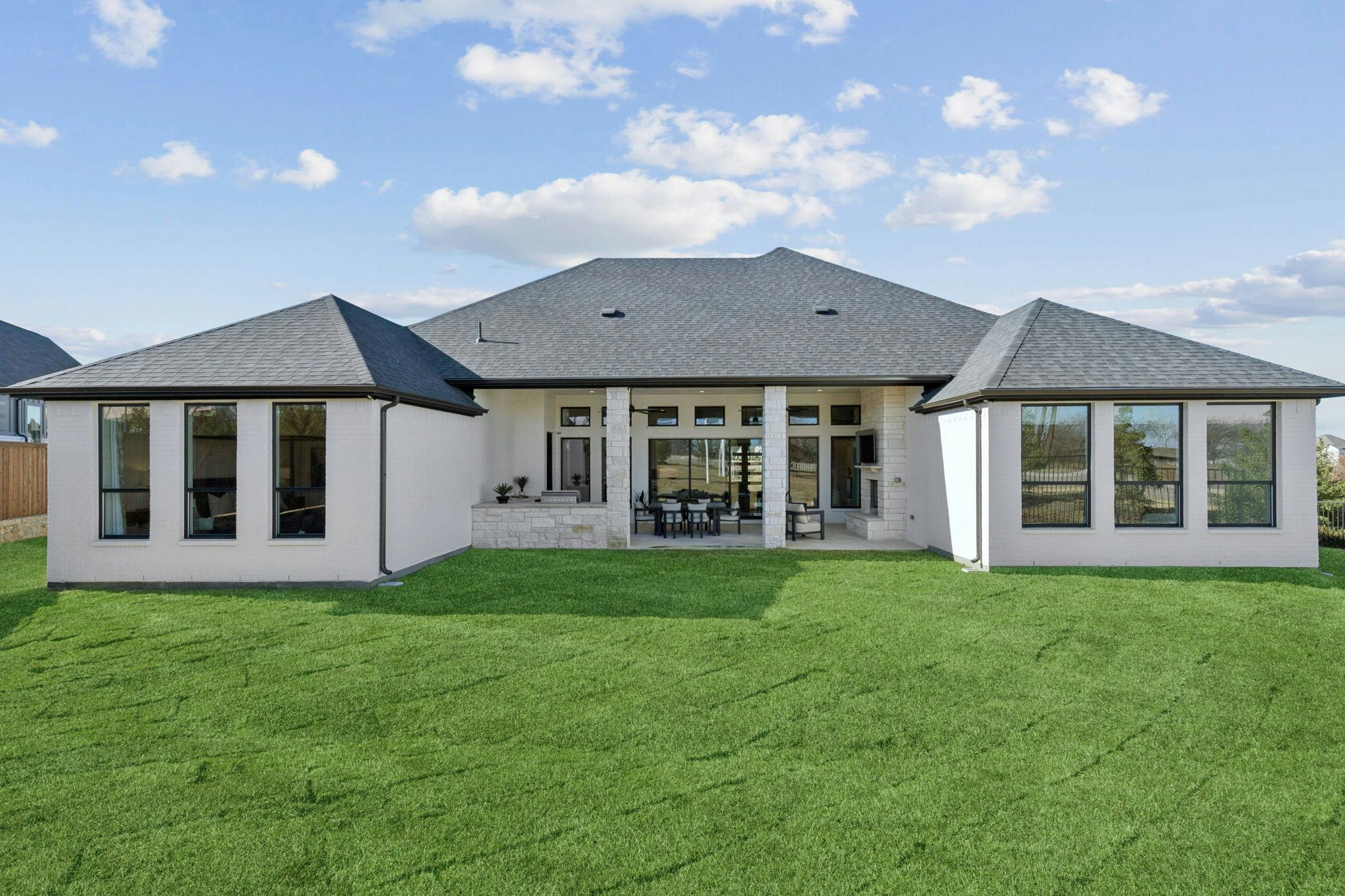 The back exterior and back yard of the custom model home at The Vines by Kindred Homes