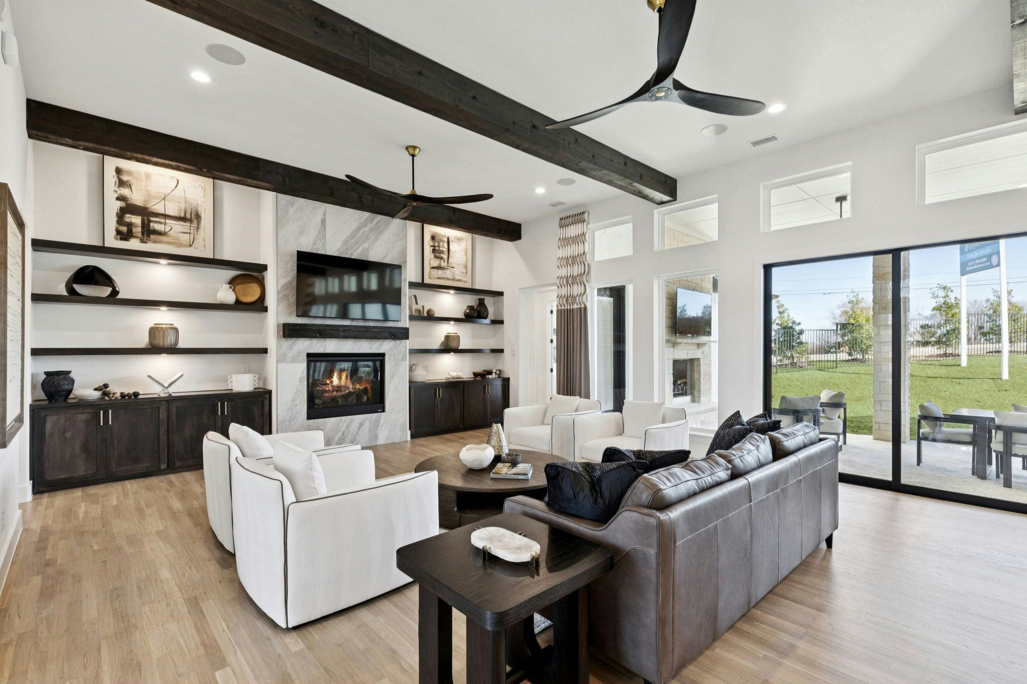 The open concept living area with a linear fireplace in the custom model home at The Vines by Kindred Homes