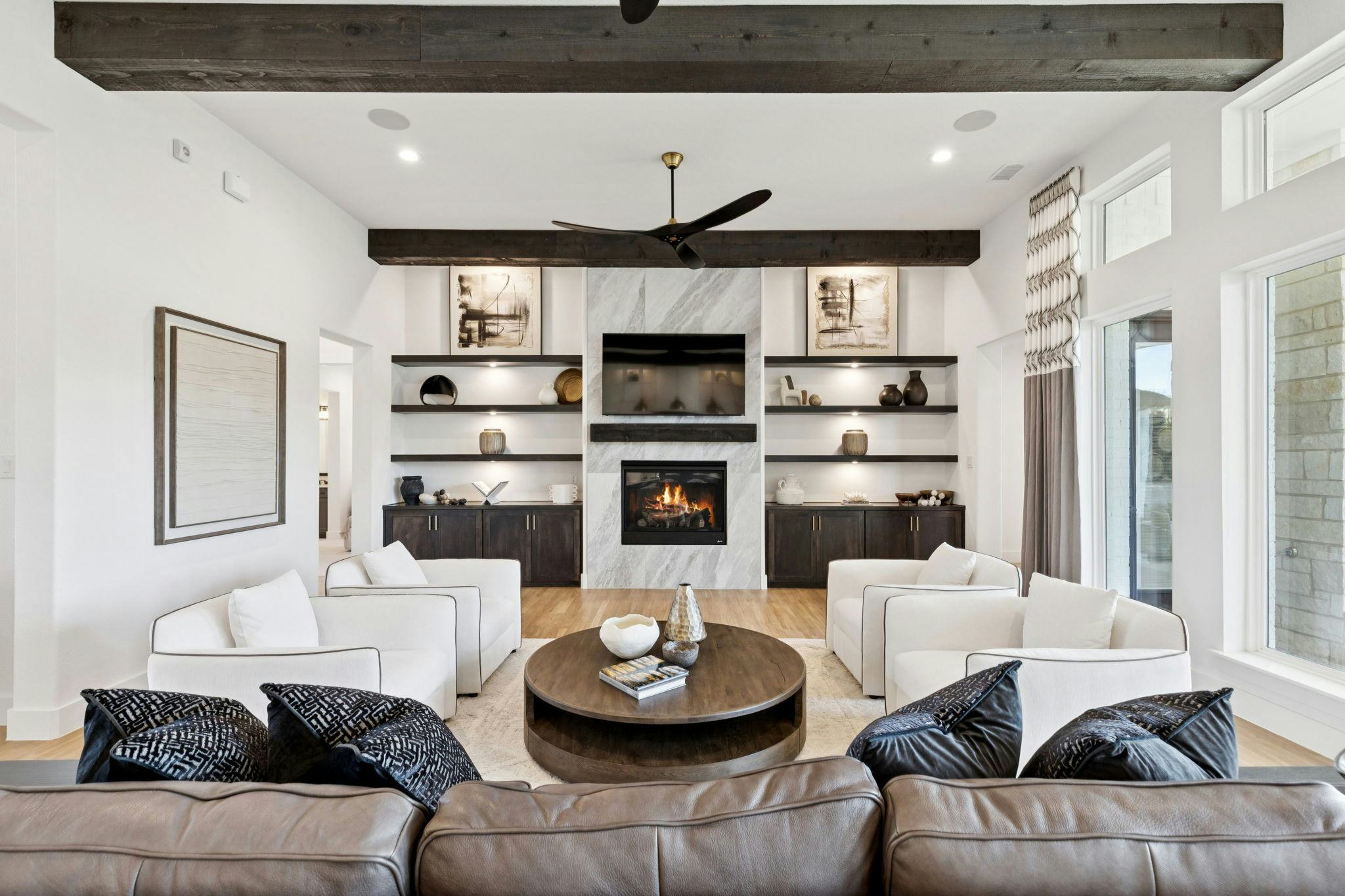 The open concept living area with a linear fireplace in the custom model home at The Vines by Kindred Homes