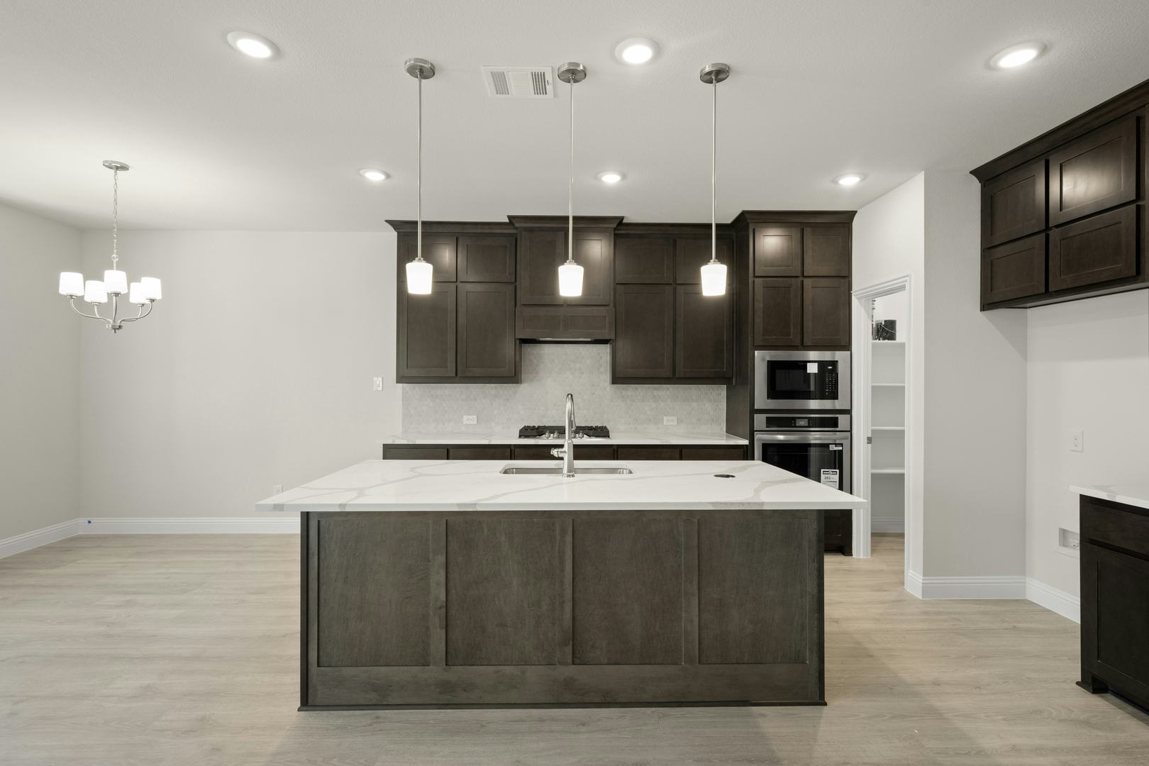The kitchen and dining nook in the Willow floor plan by Kindred Homes