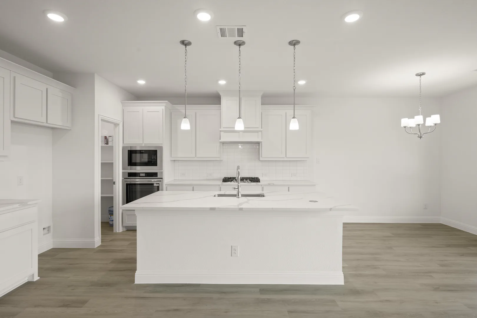 Kitchen and breakfast nook in a new traditional style home by Kindred Homes