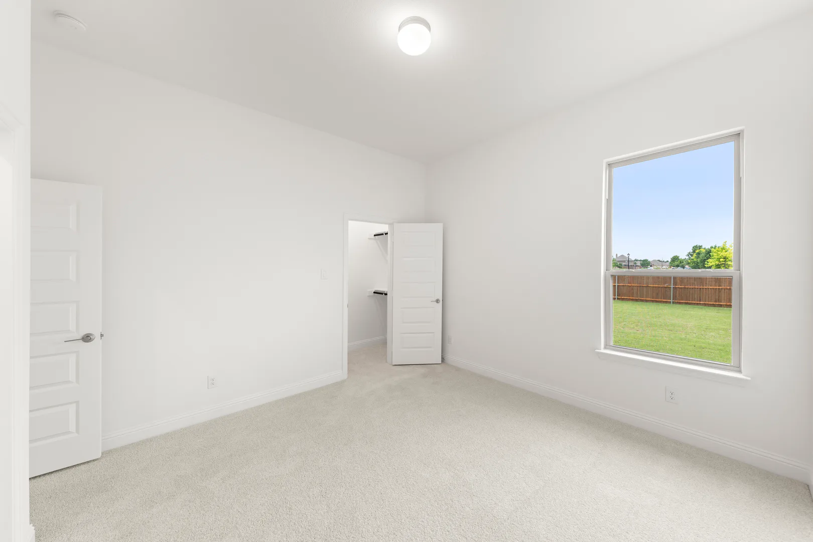 Secondary bedroom with walk-in closet in a modern tudor style home by Kindred Homes