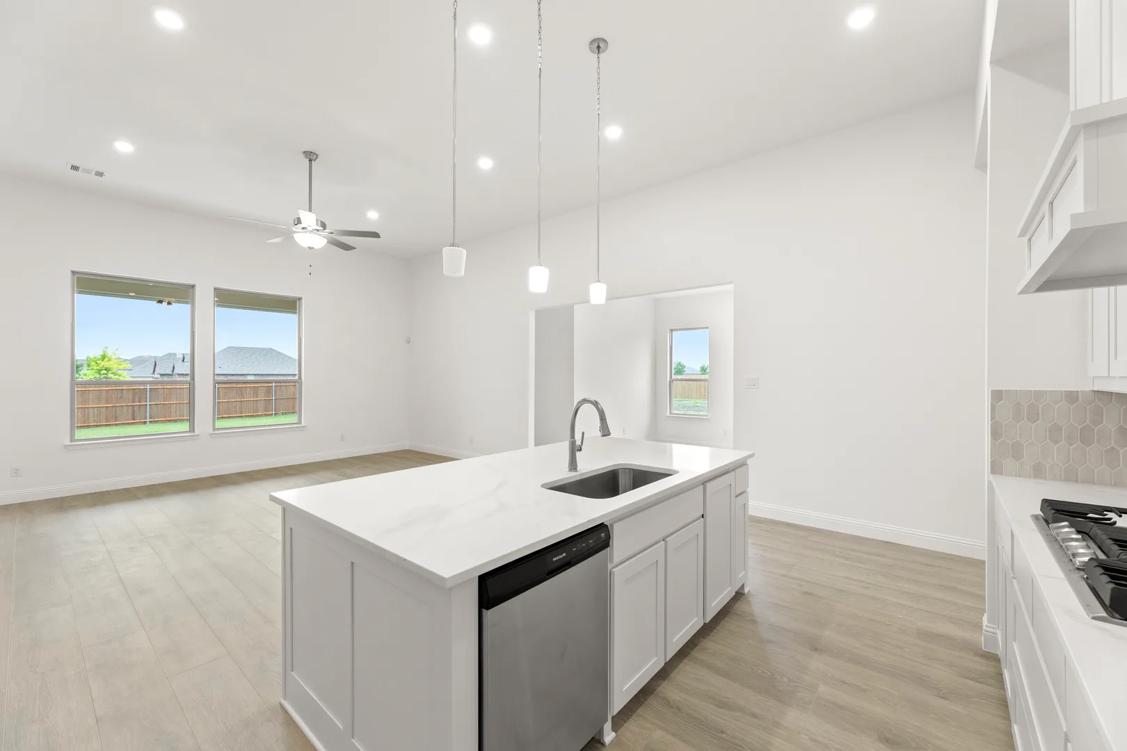 Open concept kitchen and living room in a modern tudor style home by Kindred Homes