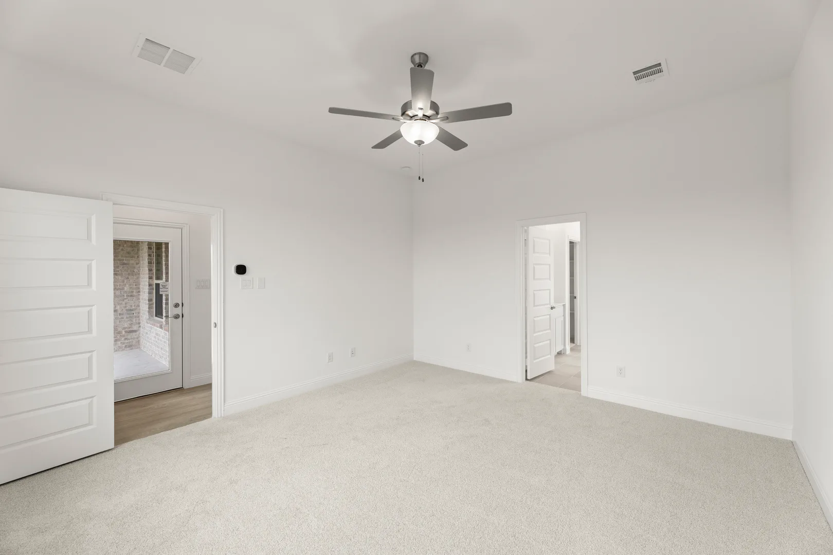 Spacious primary suite in a modern tudor style home by Kindred Homes
