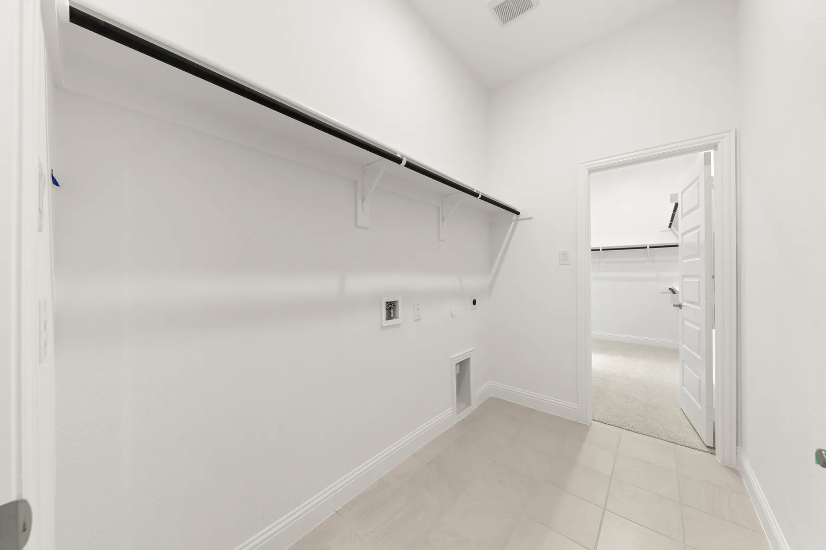 Utility room in a modern tudor style home by Kindred Homes