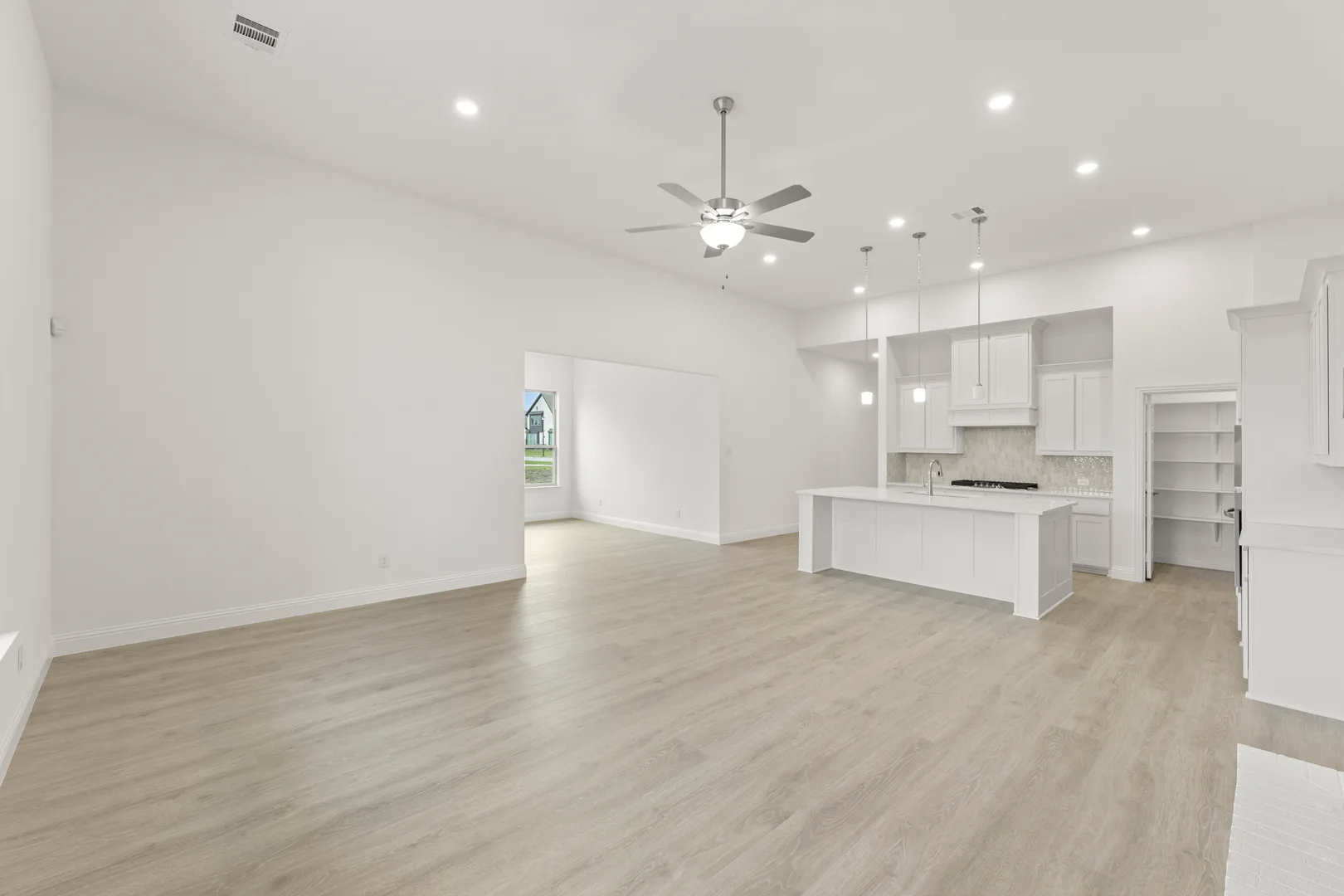Open concept living room, kitchen, and dining room in a modern tudor style home by Kindred Homes