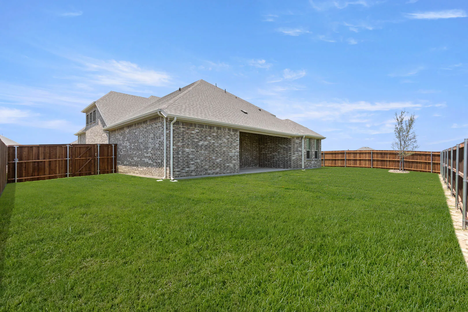 Spacious back yard of a new traditional style home by Kindred Homes