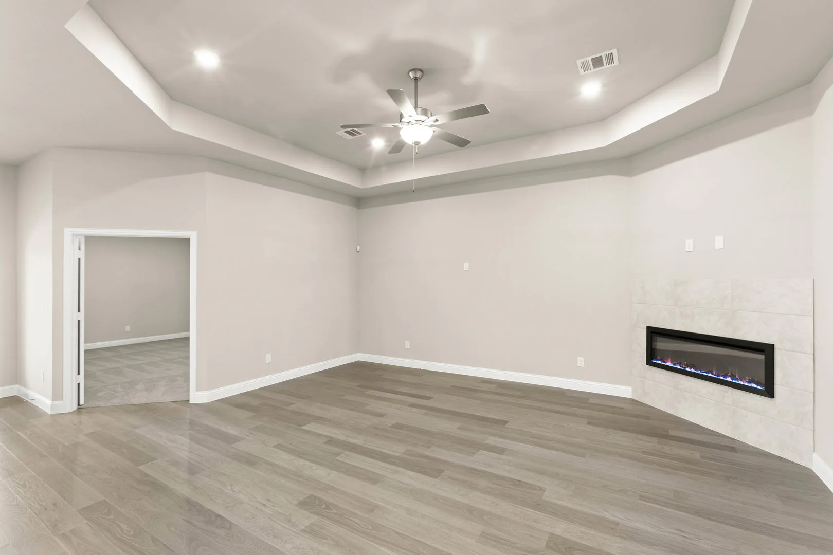 Living room with a fireplace in a new traditional style home by Kindred Homes