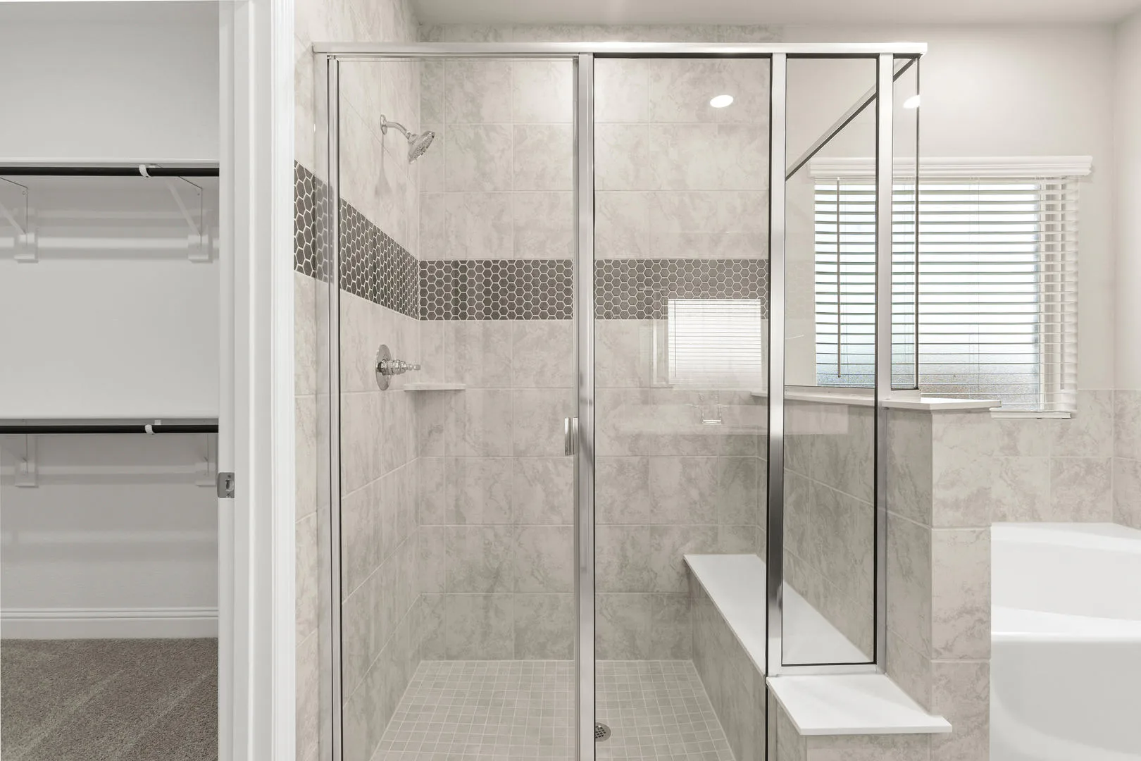 Shower in the primary bathroom in a new traditional style home by Kindred Homes