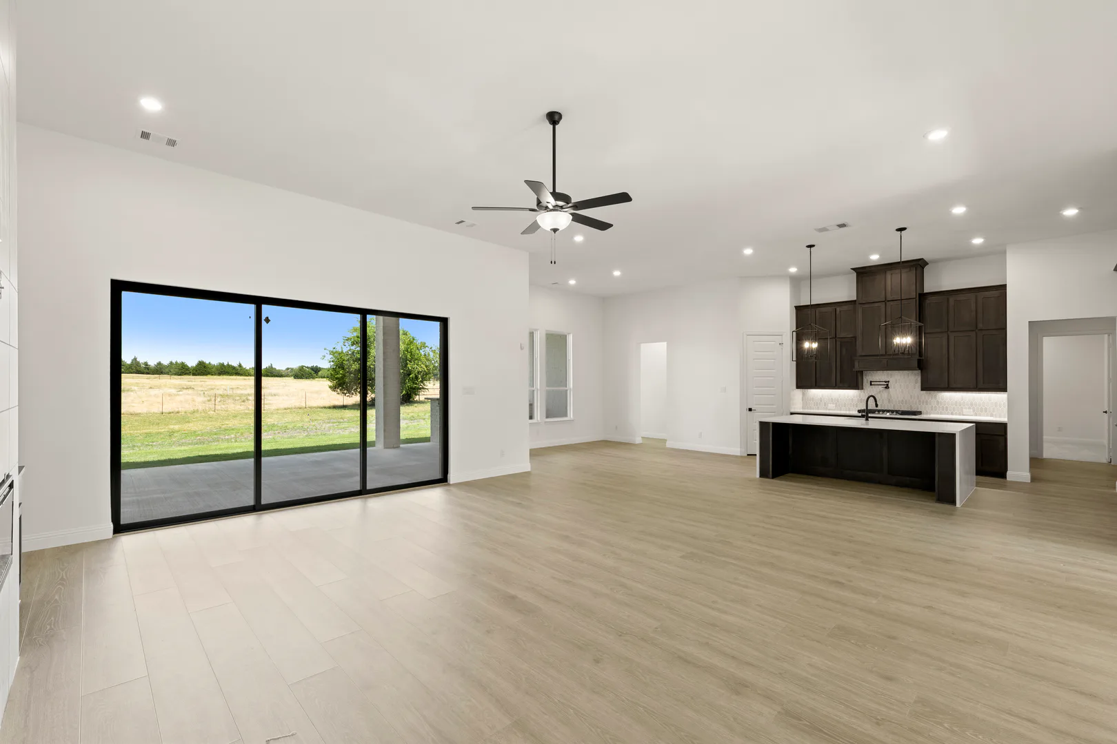 Living room, kitchen, and breakfast nook in a transitional ranch style home by Kindred Homes