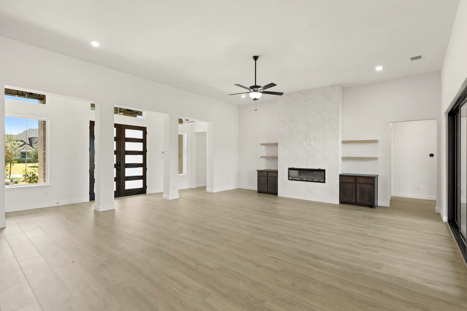 Entry and living room with fireplace in a transitional ranch style home by Kindred Homes