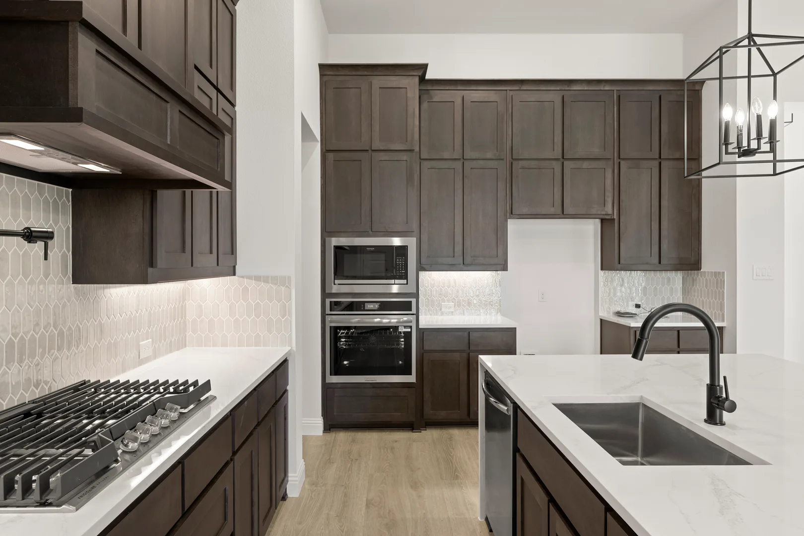 Kitchen with stainless steel appliances in a transitional ranch style home by Kindred Homes