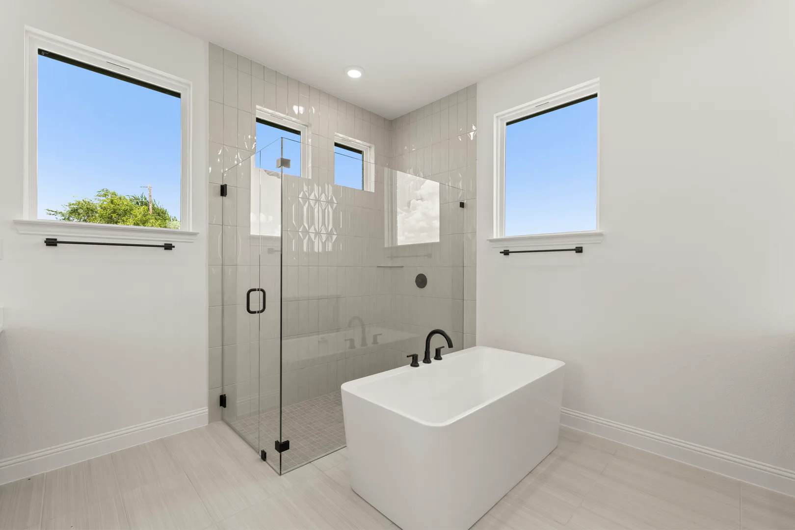Primary bathroom with freestanding tub and walk-in shower in a transitional ranch style home by Kindred Homes