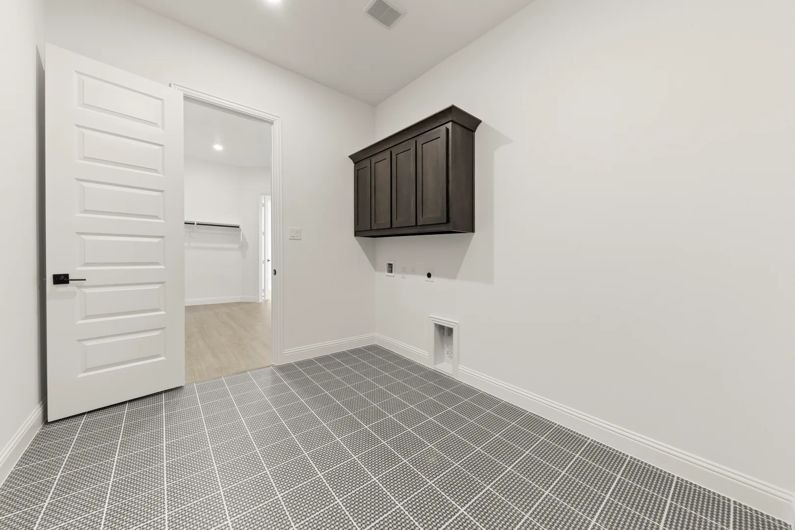 Utility room in a transitional ranch style home by Kindred Homes