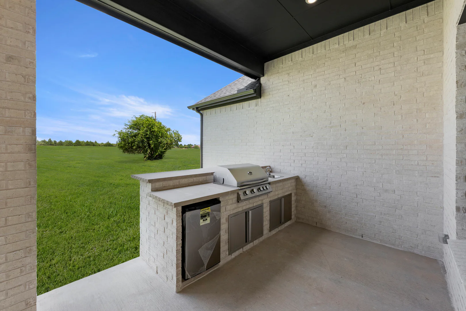 Outdoor kitchen in a transitional ranch style home by Kindred Homes