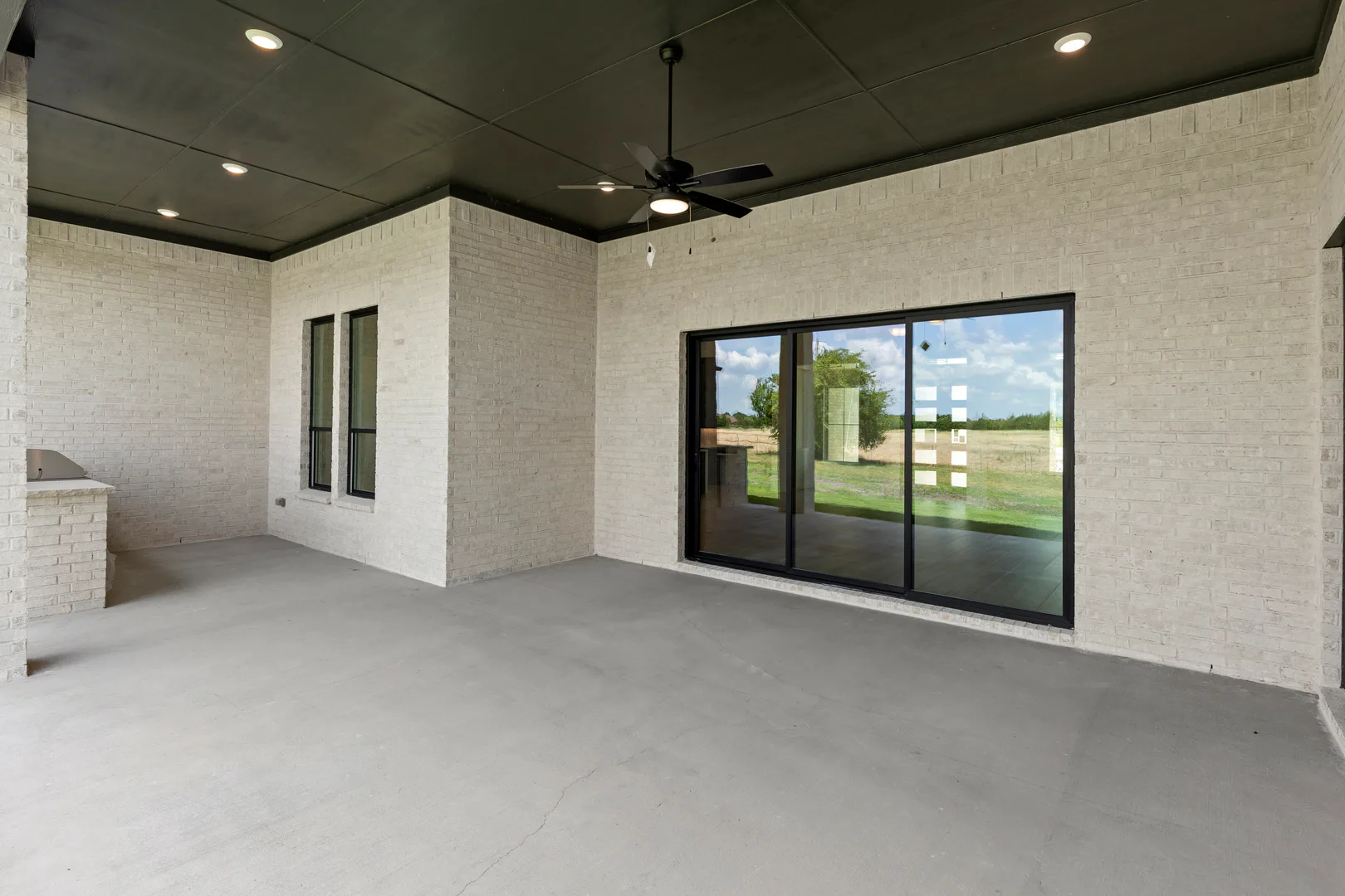 Covered patio in a transitional ranch style home by Kindred Homes
