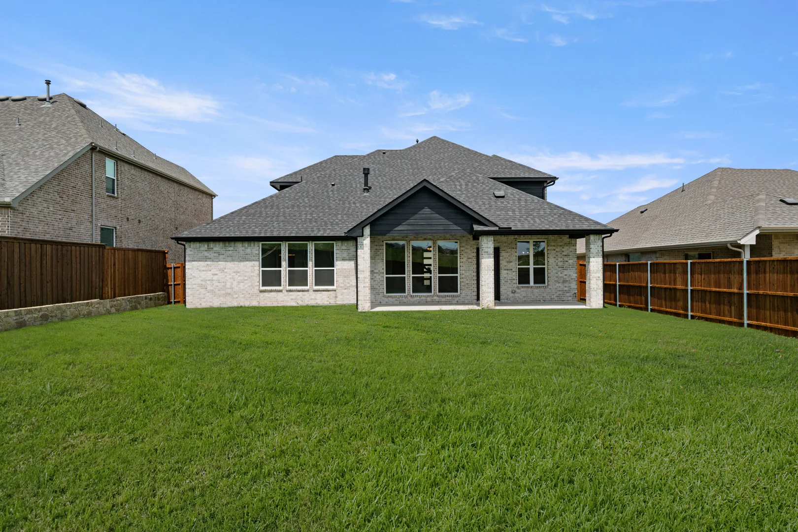 Spacious backyard of a new traditional style home by Kindred Homes