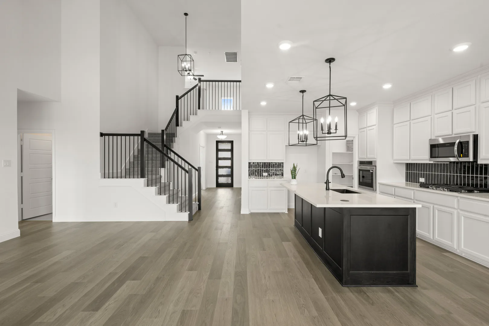 Kitchen, living room, and entryway in a new traditional style home by Kindred Homes