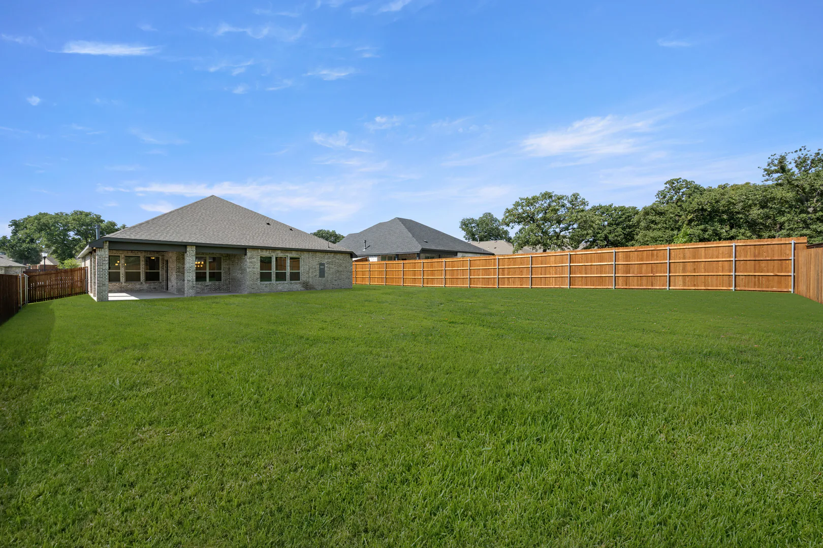 Spacious backyard of a modern farmhouse transitional style home by Kindred Homes