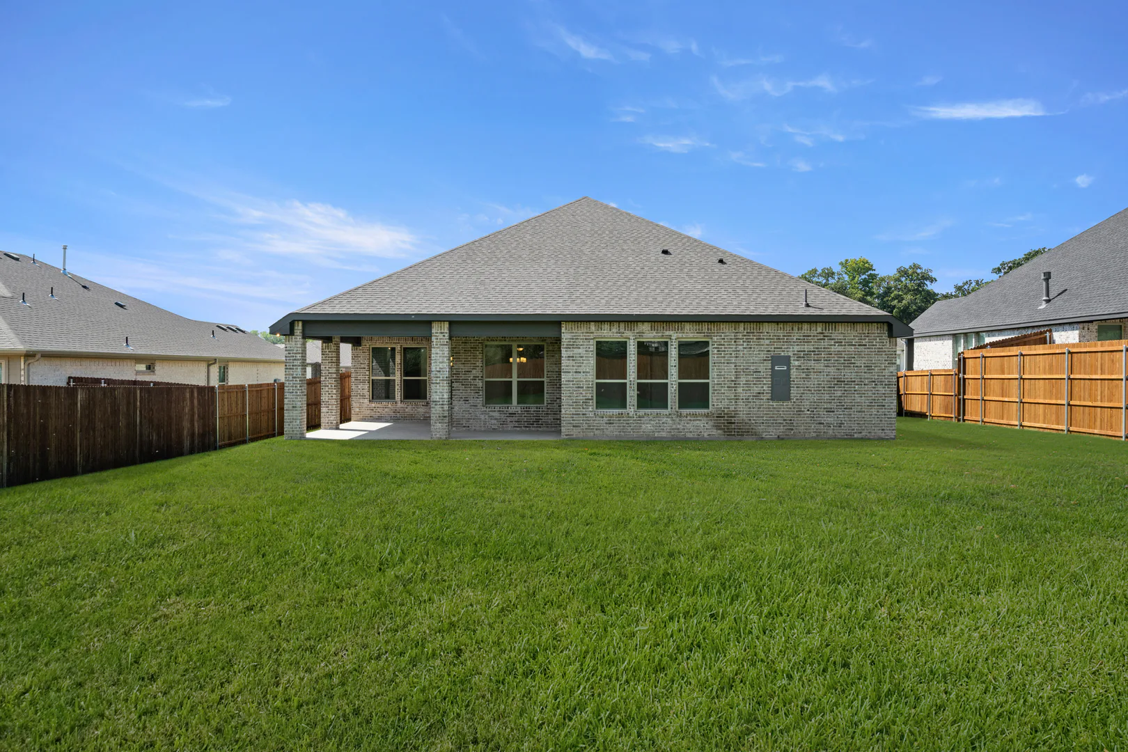 Back exterior of a modern farmhouse transitional style home by Kindred Homes
