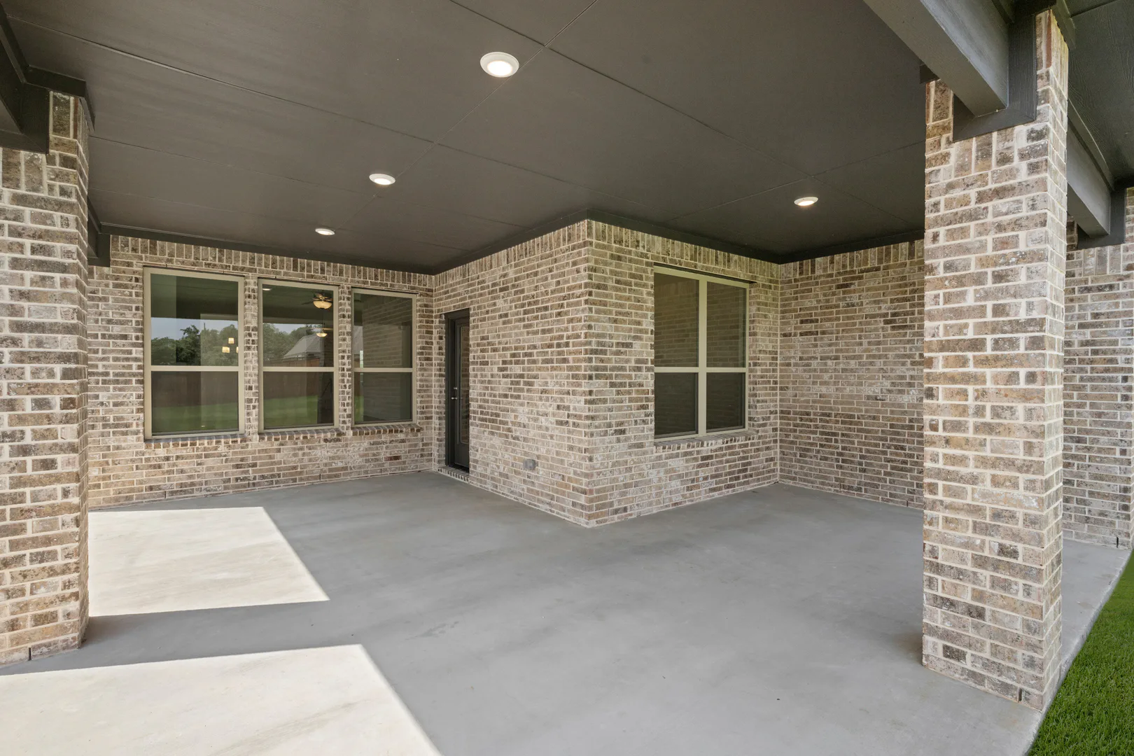 Covered outdoor patio of a modern farmhouse transitional style home by Kindred Homes