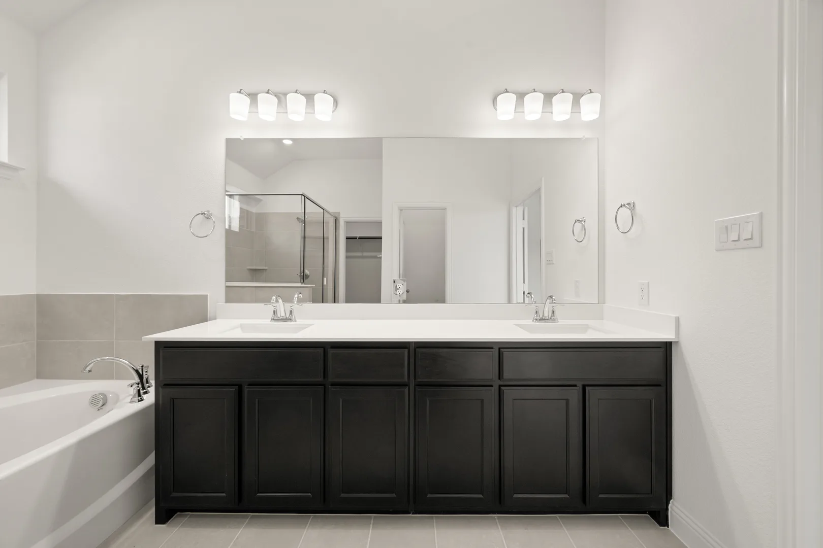 Dual vanities in a modern farmhouse transitional style home by Kindred Homes