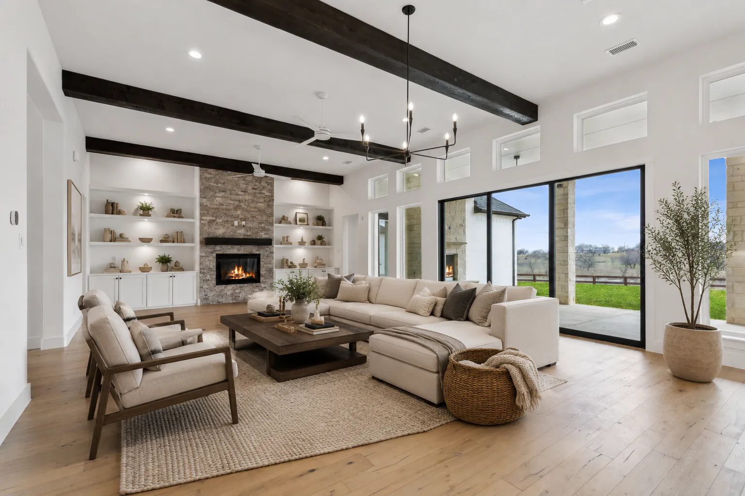 Virtually staged open concept living room with fireplace in custom home by Kindred Homes