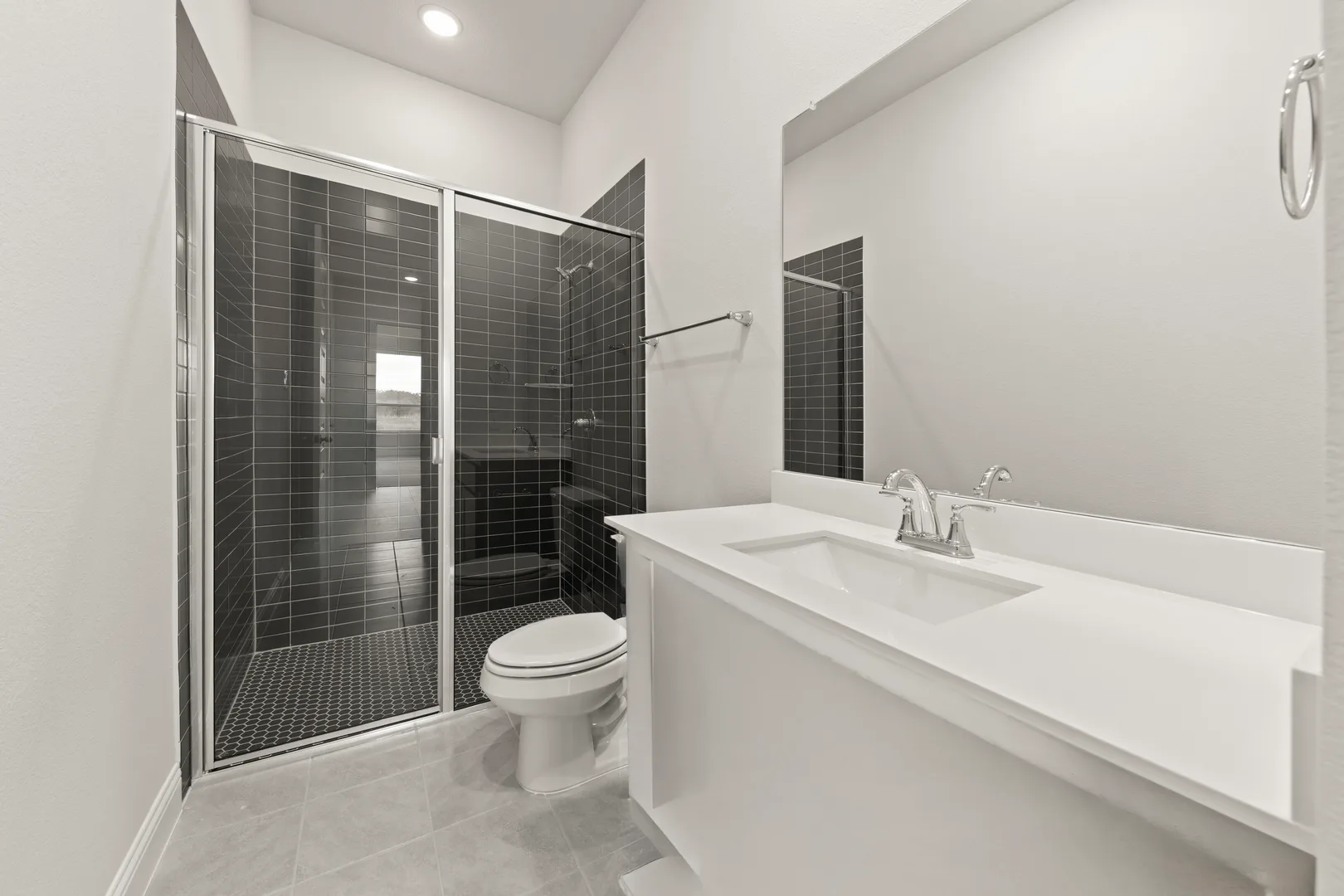 Secondary bathroom with walk-in shower in a transitional ranch style home by Kindred Homes