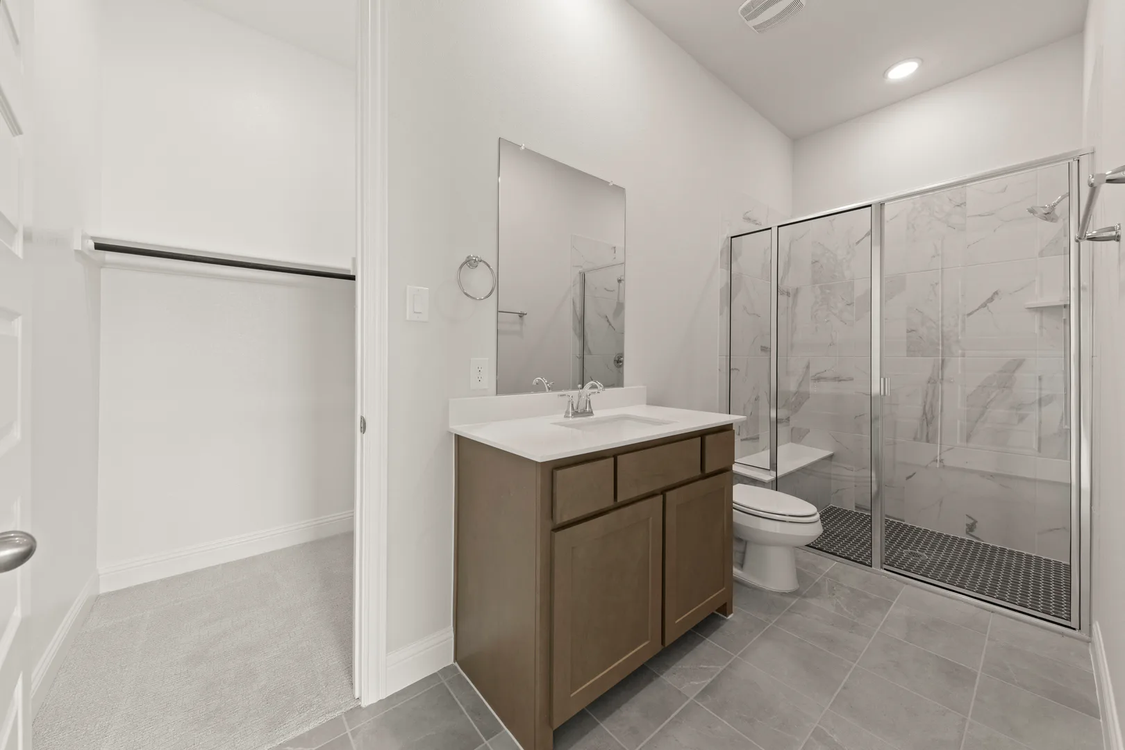 Secondary bathroom with walk-in shower in a transitional ranch style home by Kindred Homes