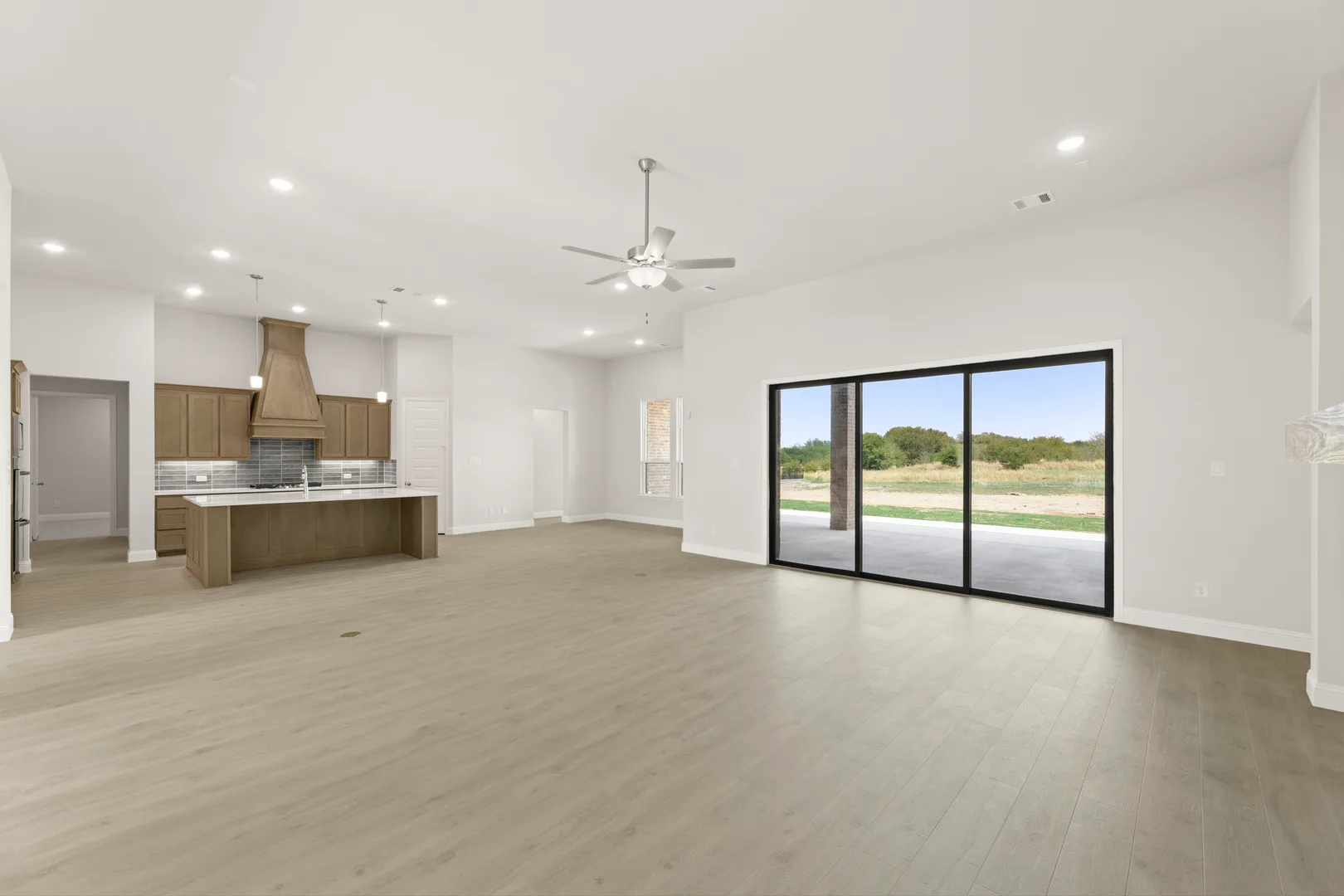 Living room and kitchen in a transitional ranch style home by Kindred Homes