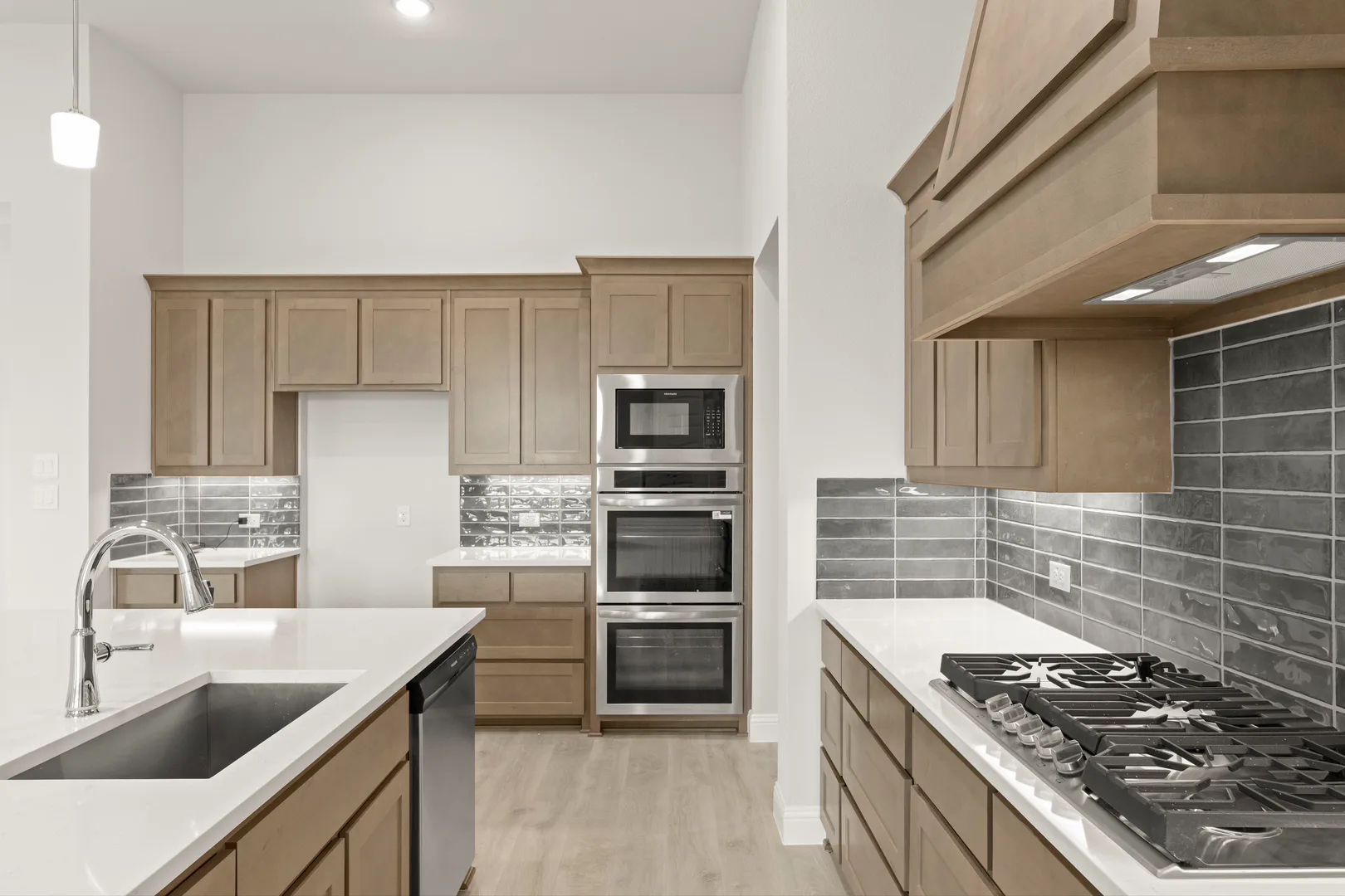 Kitchen with stainless steel appliances in a transitional ranch style home by Kindred Homes