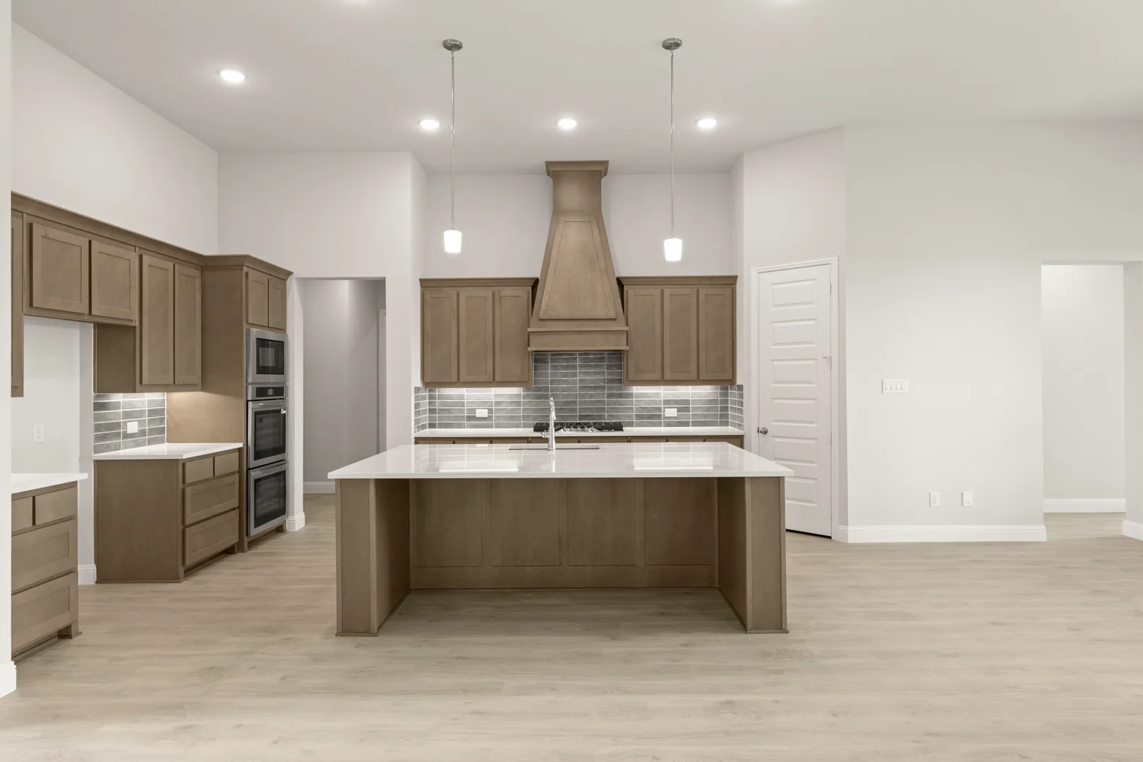 Kitchen with hood vent in a transitional ranch style home by Kindred Homes