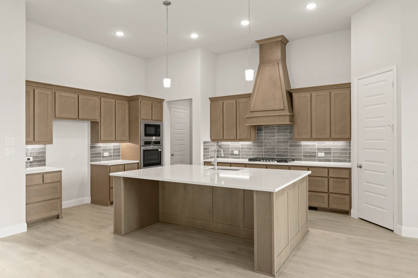 Side view of kitchen with hood vent in a transitional ranch style home by Kindred Homes