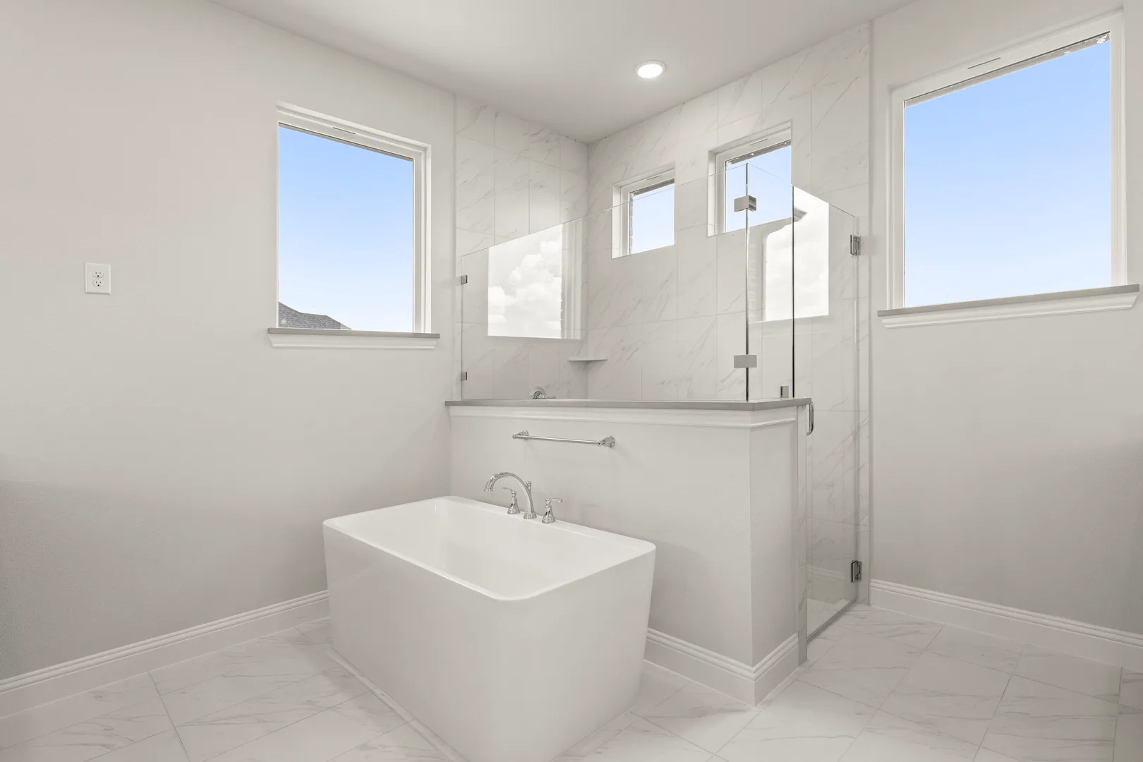 Primary bathroom with free-standing tub and walk-in shower in a transitional ranch style home by Kindred Homes