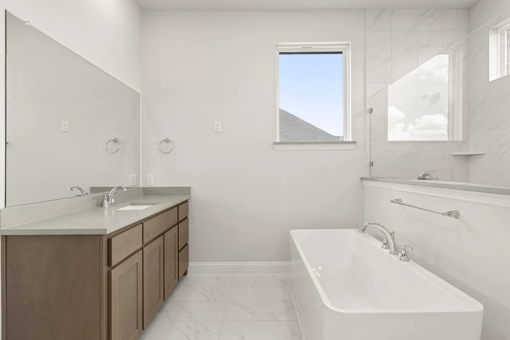 Primary bathroom with free-standing tub in a transitional ranch style home by Kindred Homes