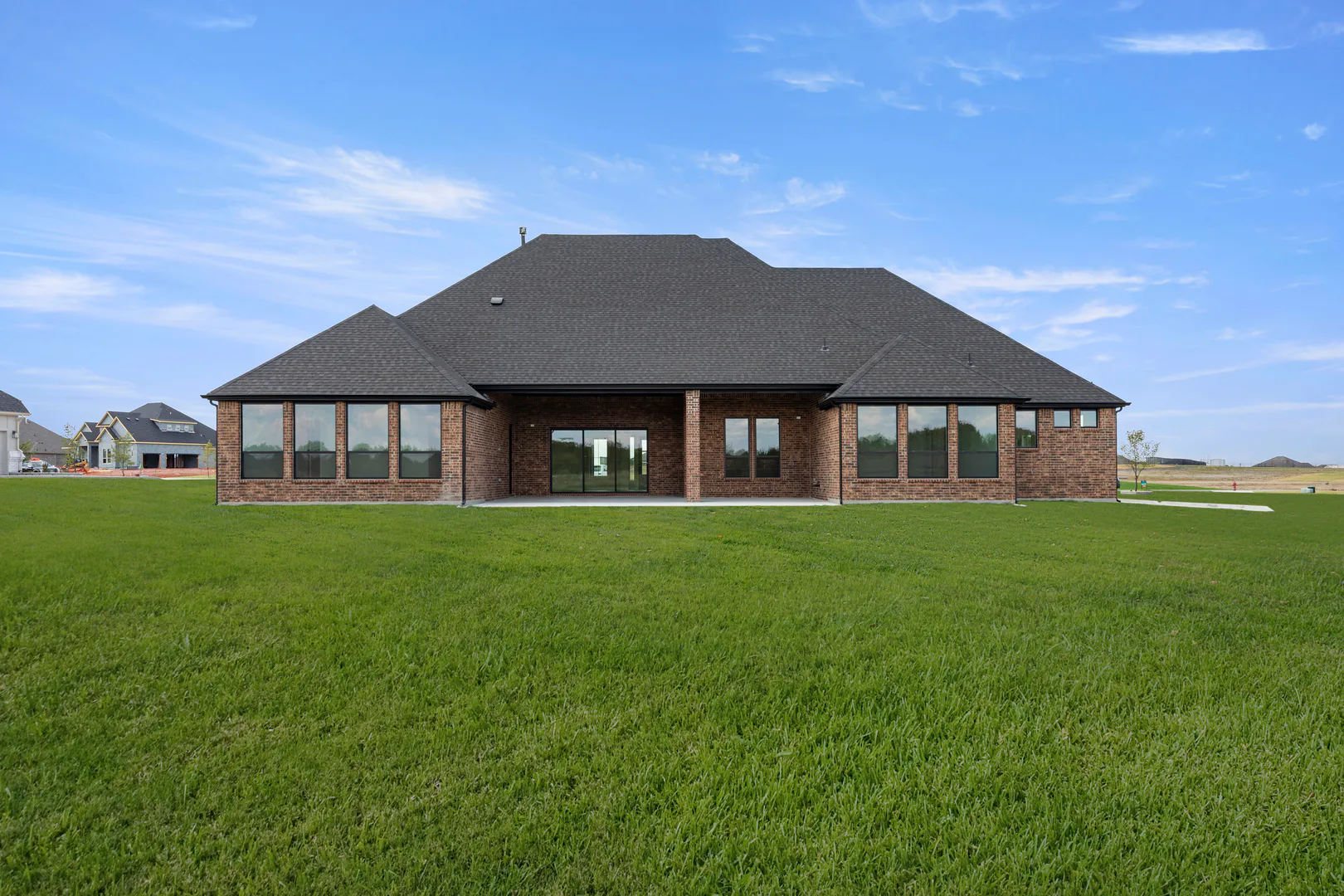 Spacious backyard and back exterior of a transitional ranch style home by Kindred Homes