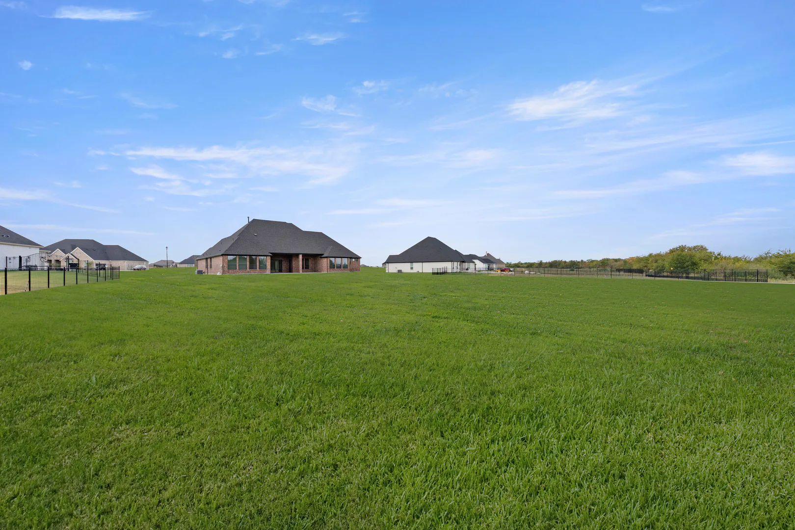 Spacious backyard of a transitional ranch style home by Kindred Homes