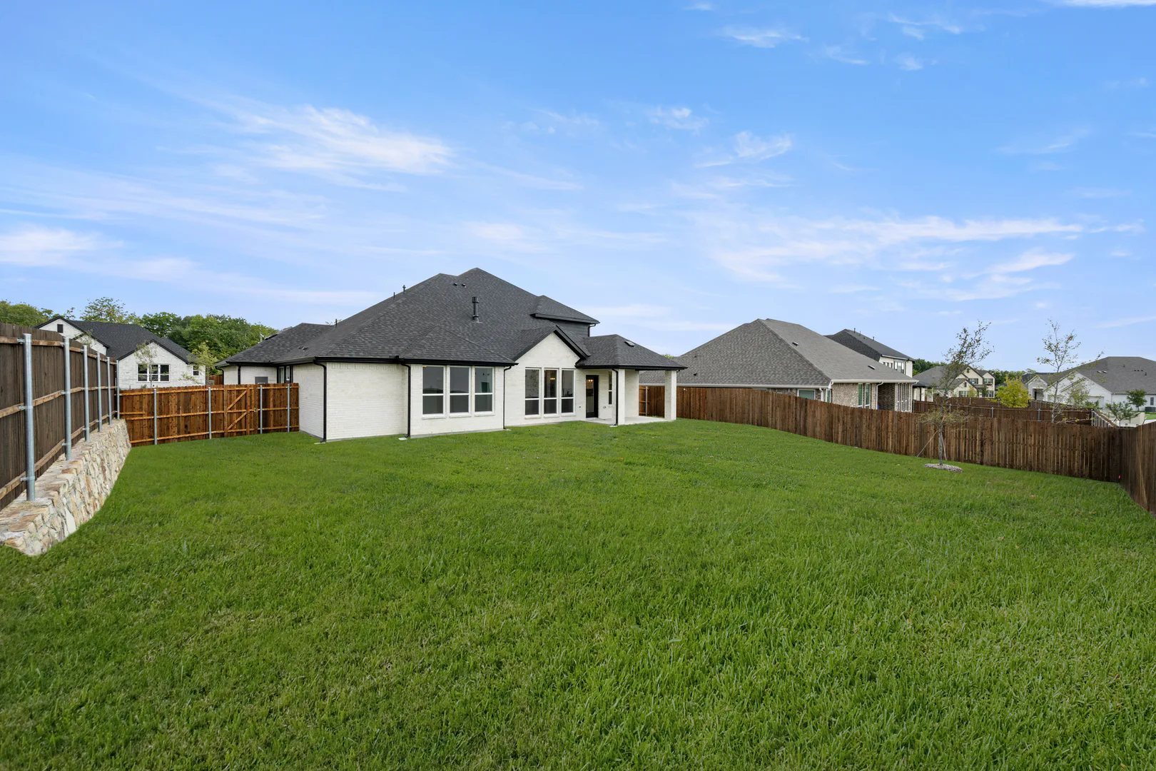 Spacious backyard of a new traditional style home by Kindred Homes