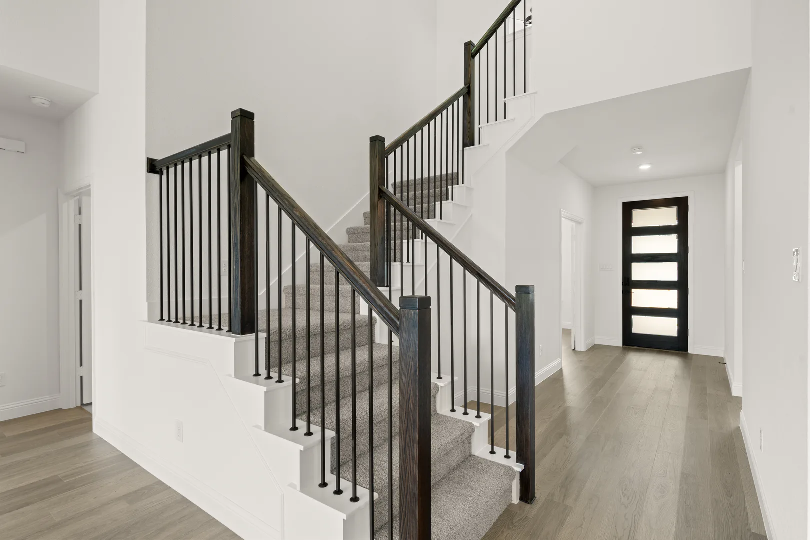 Entryway and stairs in a new traditional style home by Kindred Homes