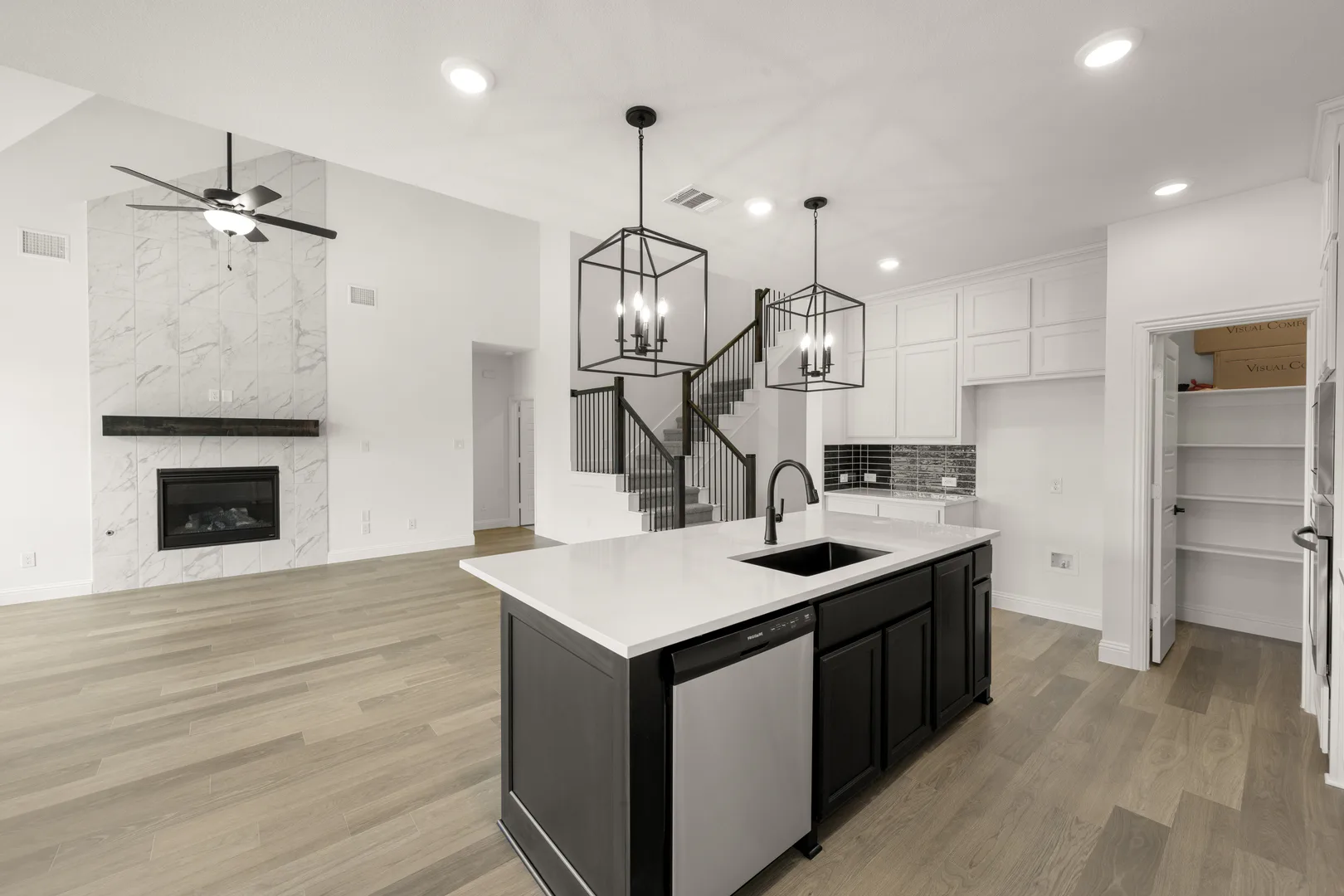 Kitchen and living room in a new traditional style home by Kindred Homes