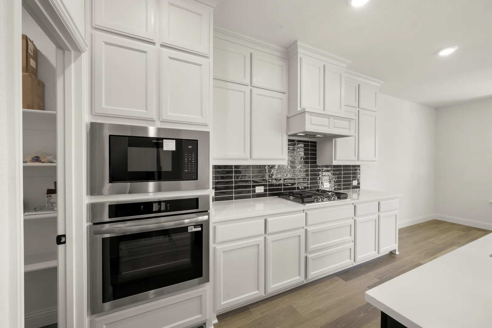 Kitchen with stainless steel appliances in a new traditional style home by Kindred Homes