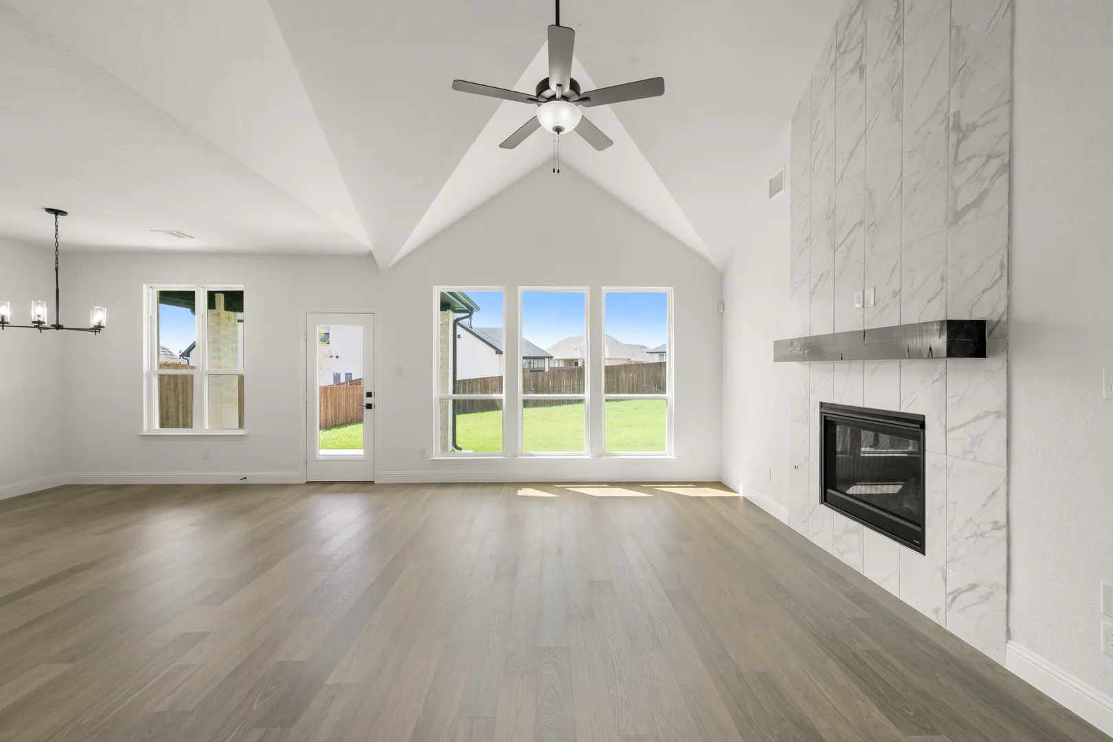 Living room with linear fireplace in a new traditional style home by Kindred Homes