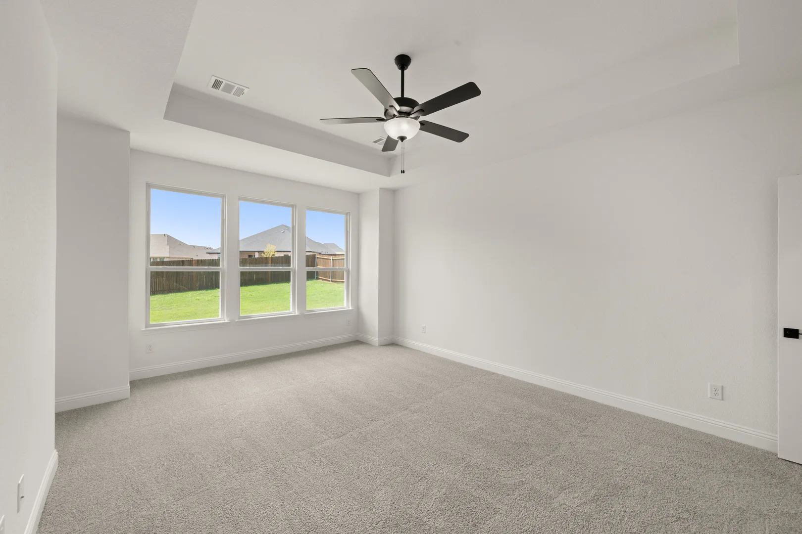 Primary bedroom in a new traditional style home by Kindred Homes