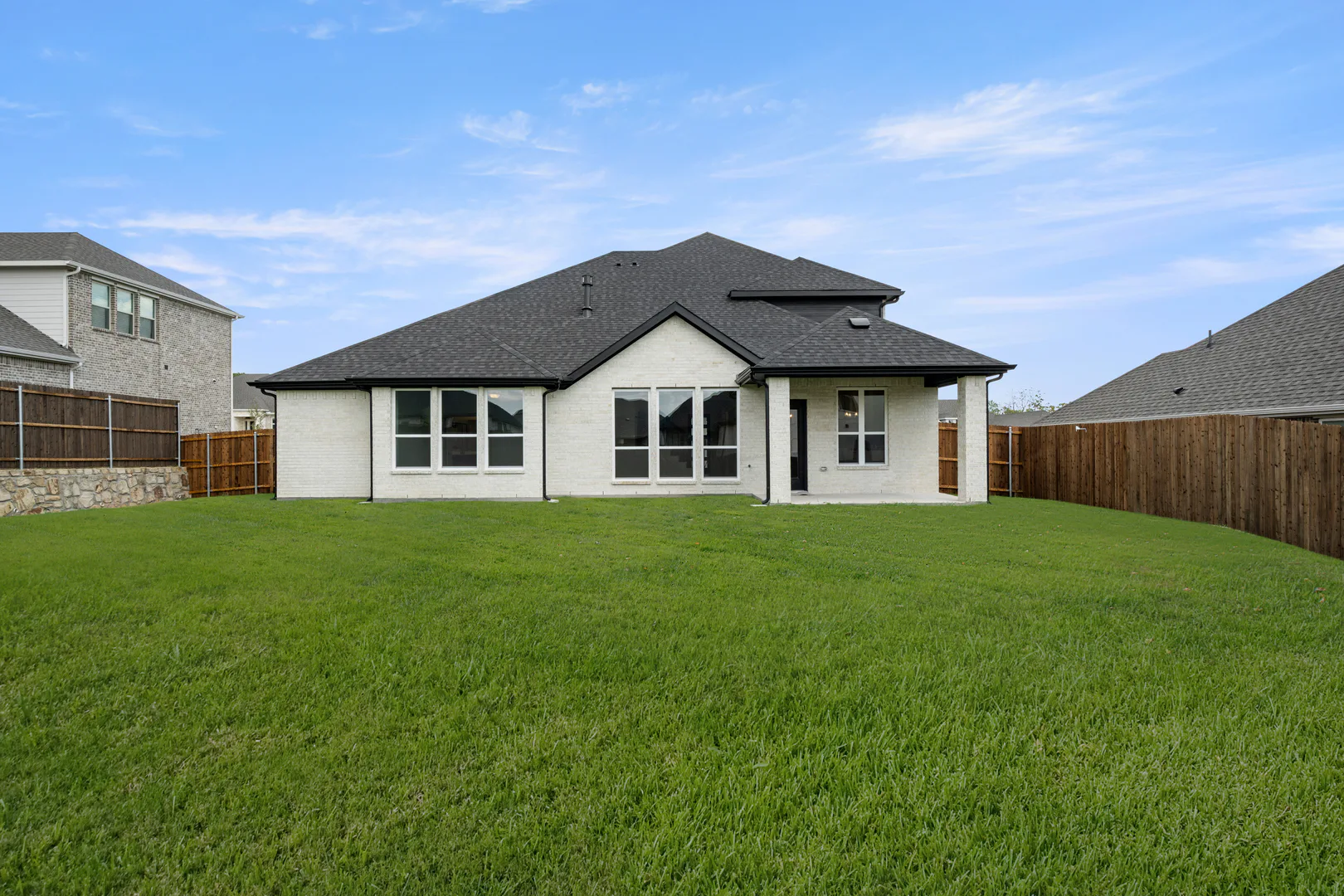 Spacious backyard of a new traditional style home by Kindred Homes