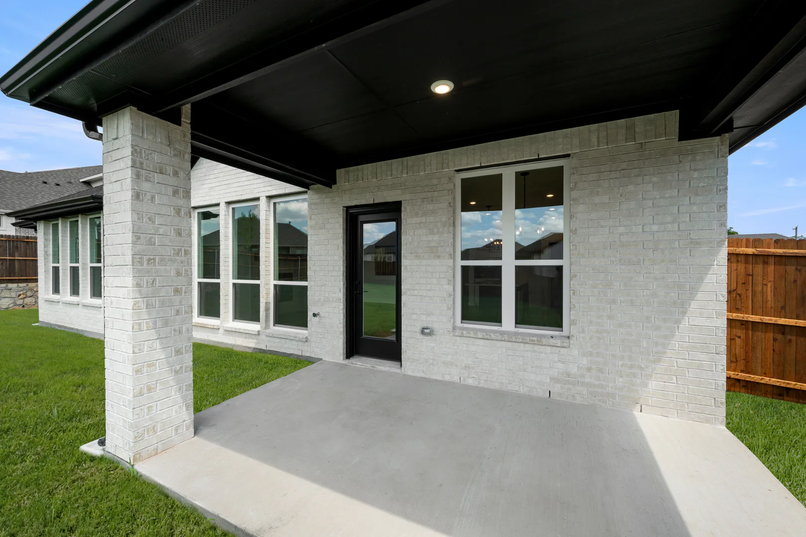 Covered patio in a new traditional style home by Kindred Homes